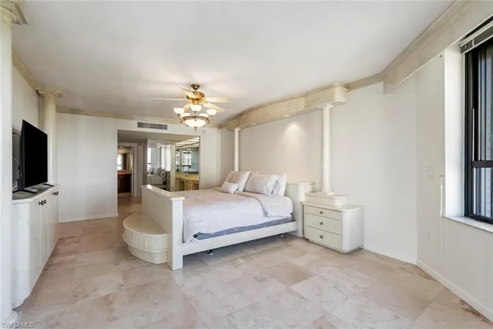 Bedroom with ceiling fan, ornamental molding, and multiple windows