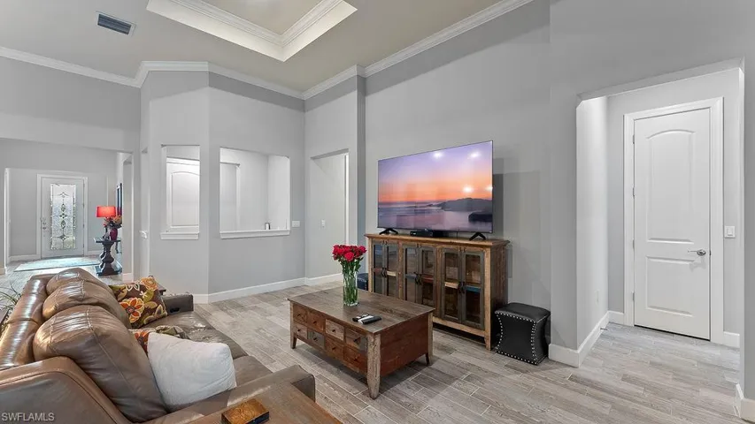 Living room with crown molding and light wood-type flooring