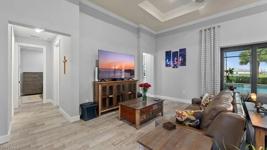 Living room with light hardwood / wood-style floors and ornamental molding