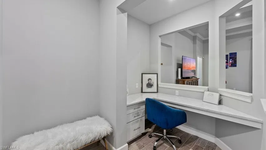 Home office with ornamental molding, hardwood / wood-style floors, and built in desk