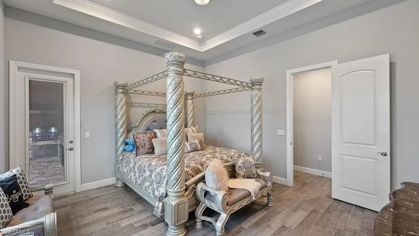 Bedroom with a raised ceiling and hardwood / wood-style floors