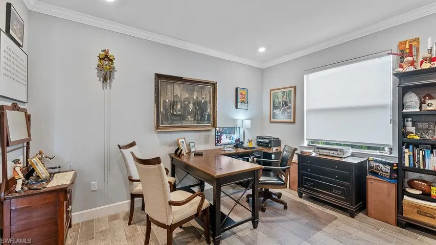 Office area featuring light hardwood / wood-style flooring and crown molding