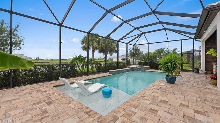 View of pool with an in ground hot tub, a lanai, and a patio area