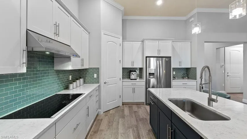 Kitchen with pendant lighting, light hardwood / wood-style flooring, and decorative backsplash