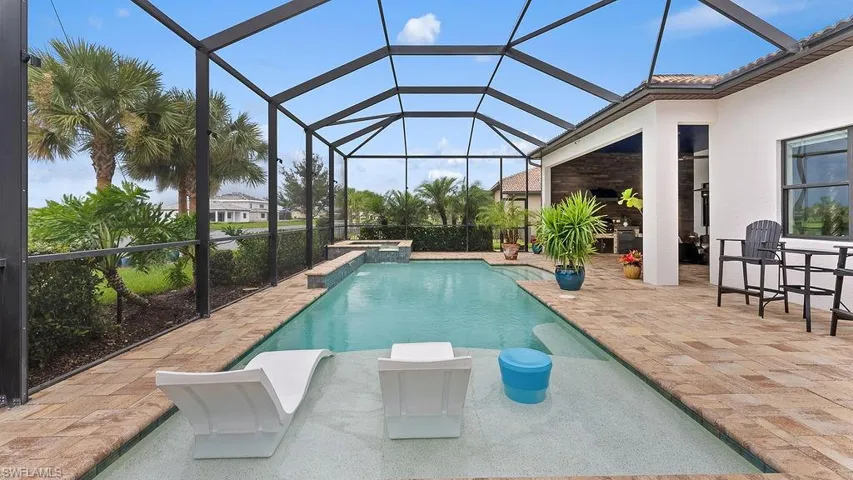 View of swimming pool with a patio area and glass enclosure