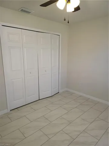 Unfurnished bedroom with a closet and ceiling fan