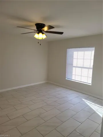 Spare room featuring baseboards and ceiling fan