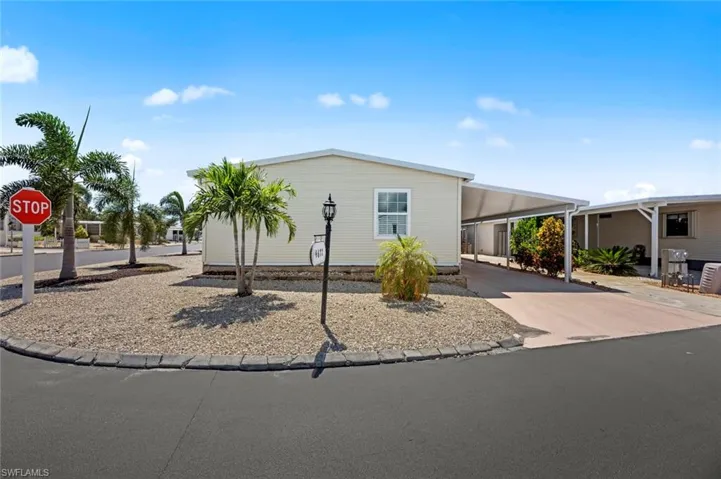 Manufactured / mobile home featuring a carport and concrete driveway