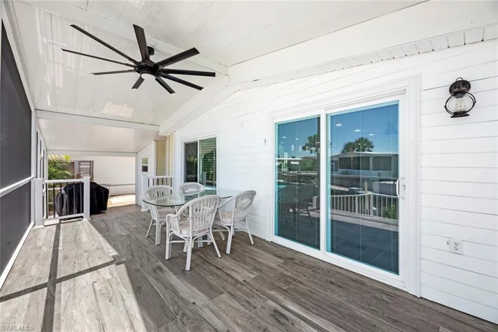 Sunroom with a ceiling fan and outdoor dining space