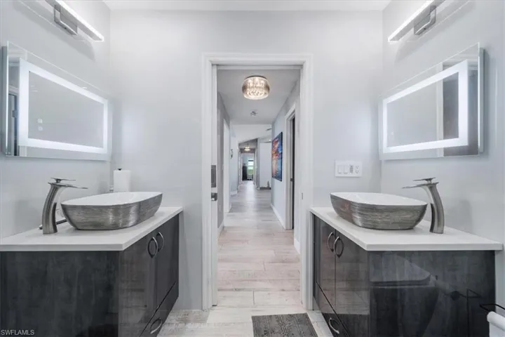 Bathroom with toilet, vanity, and a shower with door