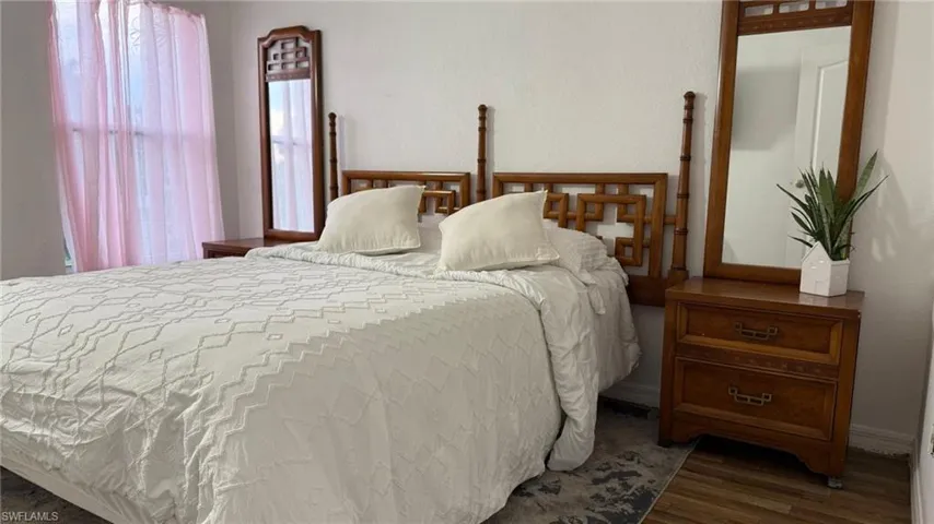 Bedroom featuring wood finished floors and baseboards