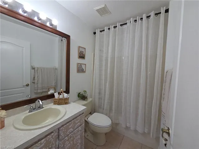 Full bath featuring tile patterned flooring, vanity, and shower / bathtub combination with curtain