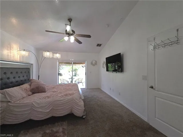 Bedroom featuring lofted ceiling, carpet floors, a ceiling fan, and access to exterior