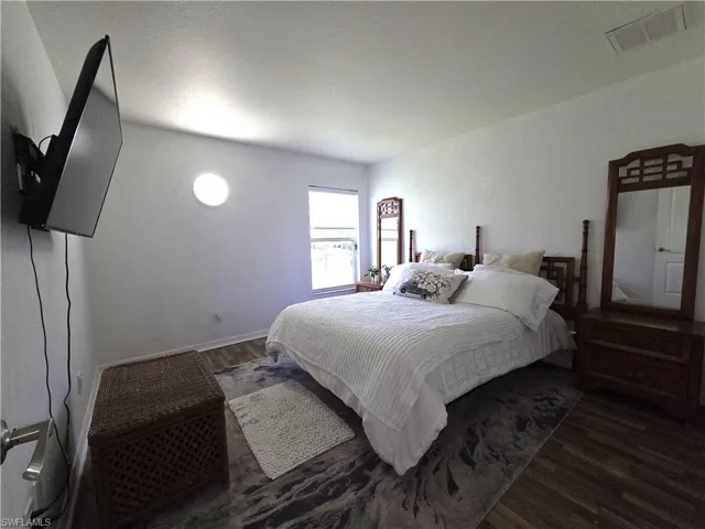 Bedroom with wood finished floors and baseboards