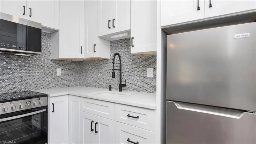 Kitchen with white cabinets, light countertop, stainless steel appliances