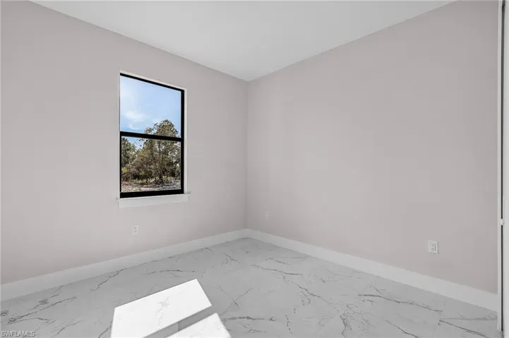 Spare room featuring marble finish floor and baseboards