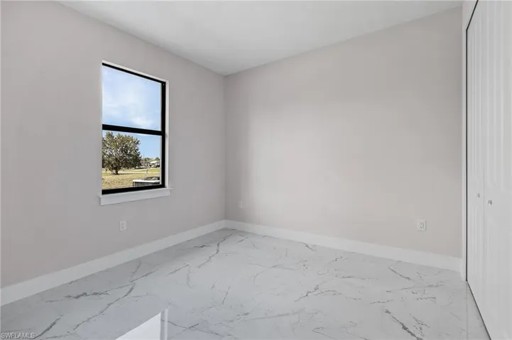 Unfurnished room featuring marble finish floor and baseboards