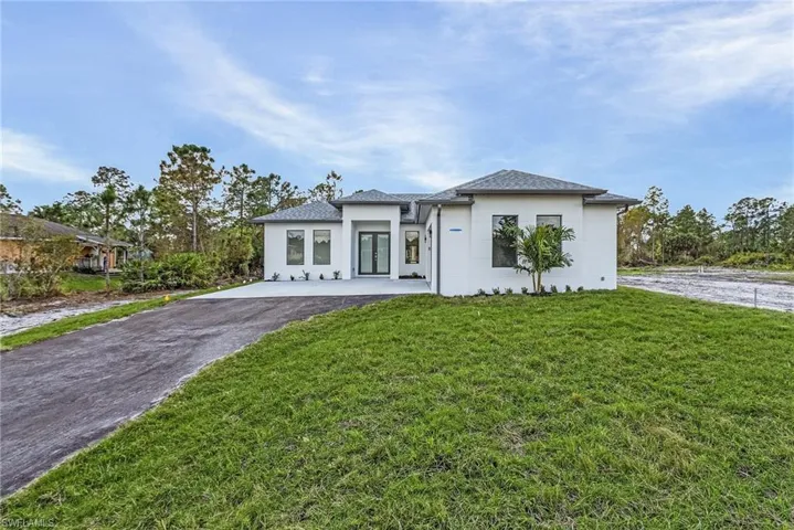 View of front of house with a front yard and stucco siding