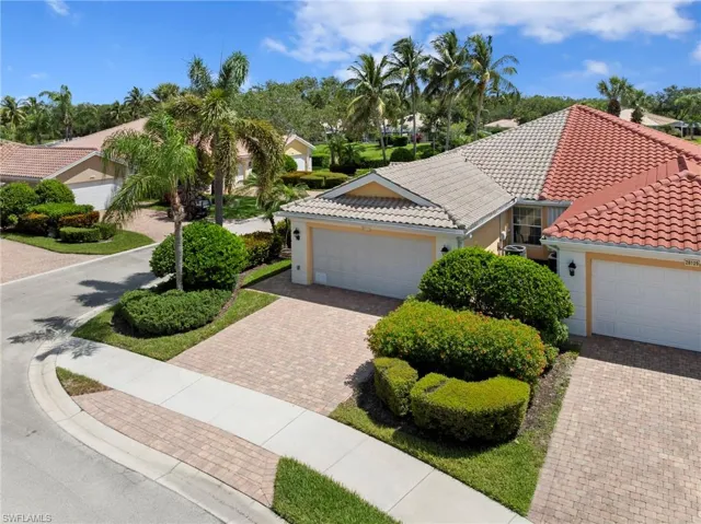 View of front of property featuring a tiled roof, decorative driveway, an attached garage, and stucco siding