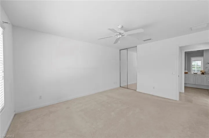 Unfurnished bedroom featuring light carpet, a closet, and ceiling fan