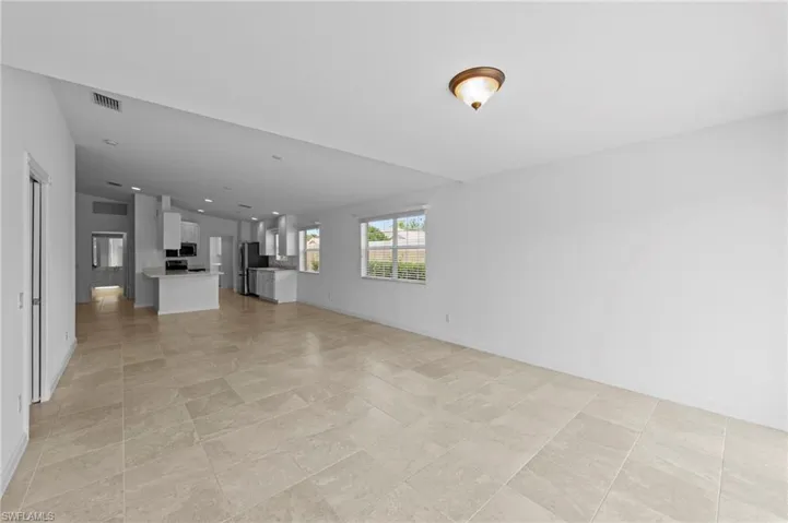 Unfurnished living room featuring baseboards and recessed lighting