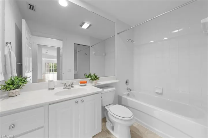 Full bath featuring vanity, shower / tub combination, and tile patterned floors