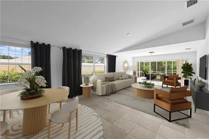 Living area with vaulted ceiling, healthy amount of natural light, and light tile patterned flooring