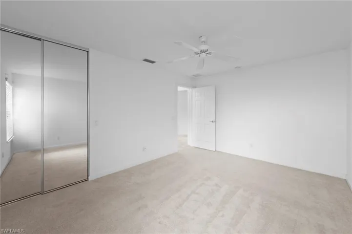 Unfurnished bedroom with carpet, a closet, and a ceiling fan