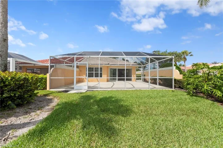 Back of house with stucco siding, a patio area, a lawn, a lanai, and a tiled roof