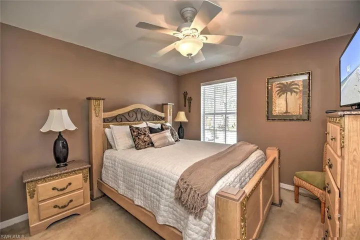 Bedroom featuring baseboards, light colored carpet, and ceiling fan
