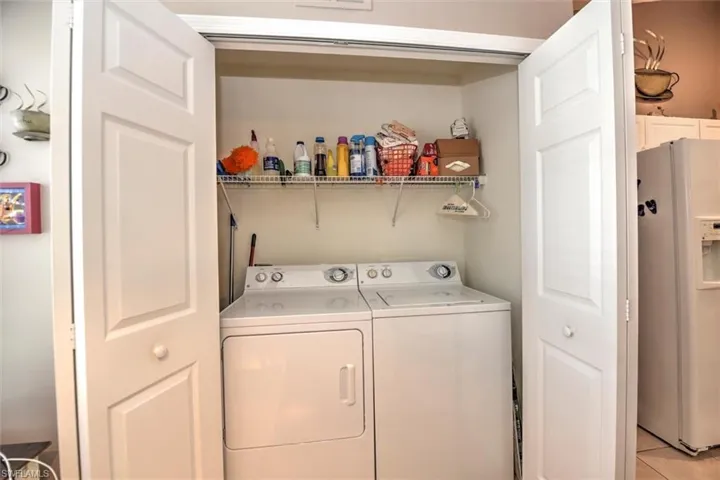 Washroom featuring light tile patterned floors, washer and dryer, and laundry area