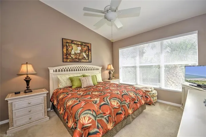 Bedroom featuring baseboards, a ceiling fan, carpet flooring, and lofted ceiling