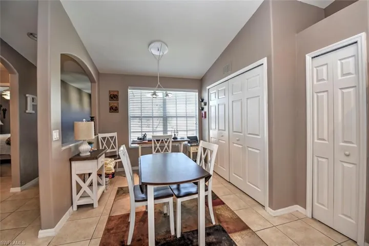 Dining space with arched walkways, visible vents, baseboards, and light tile patterned flooring