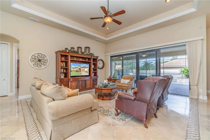 Living room with a tray ceiling and ceiling fan