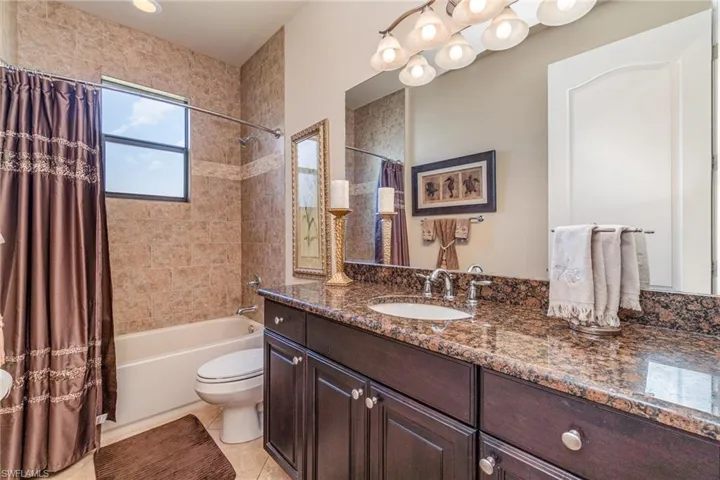 Full bathroom featuring tile patterned floors, vanity, shower / bathtub combination with curtain, and toilet