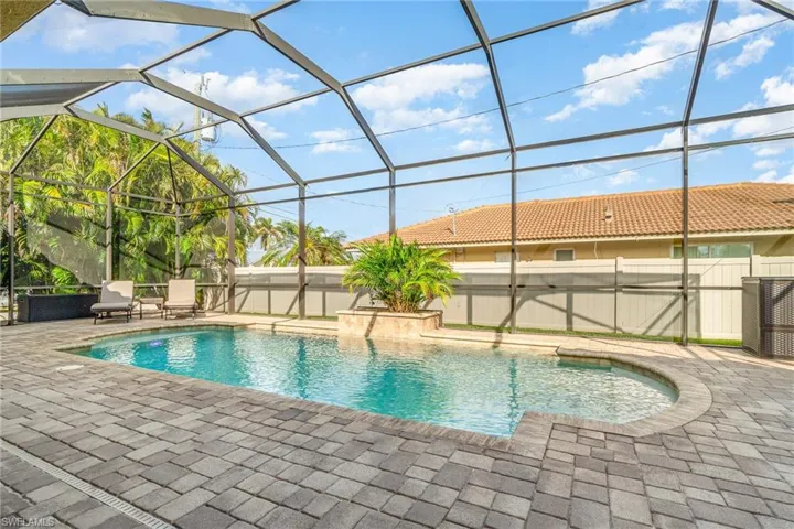 View of swimming pool with a patio and glass enclosure