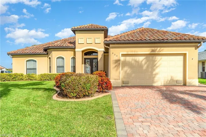 Mediterranean / spanish house with french doors, a front yard, and a garage