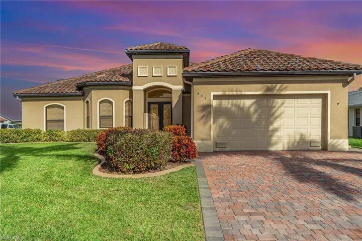 Mediterranean / spanish house featuring a lawn and a garage