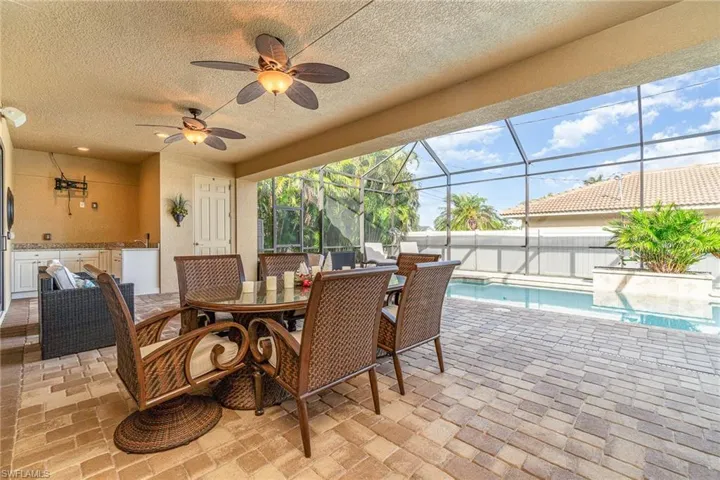 View of patio with ceiling fan, a lanai, and exterior kitchen