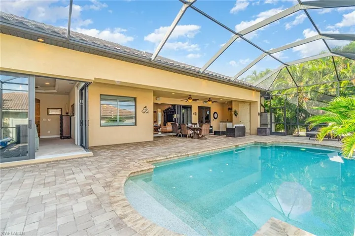 View of pool featuring a lanai, a patio area, and ceiling fan