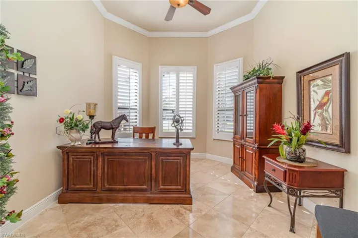 Home office with ceiling fan and crown molding