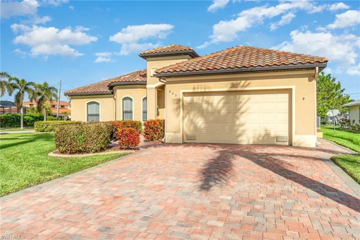 Mediterranean / spanish house featuring a garage and a front lawn