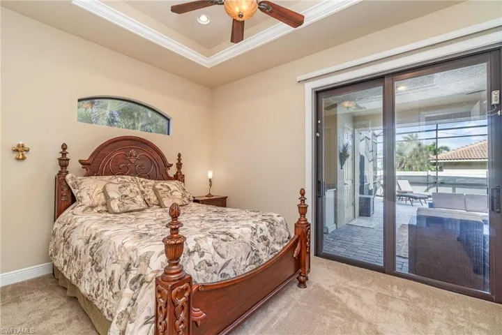 Bedroom with access to outside, multiple windows, ceiling fan, and light colored carpet