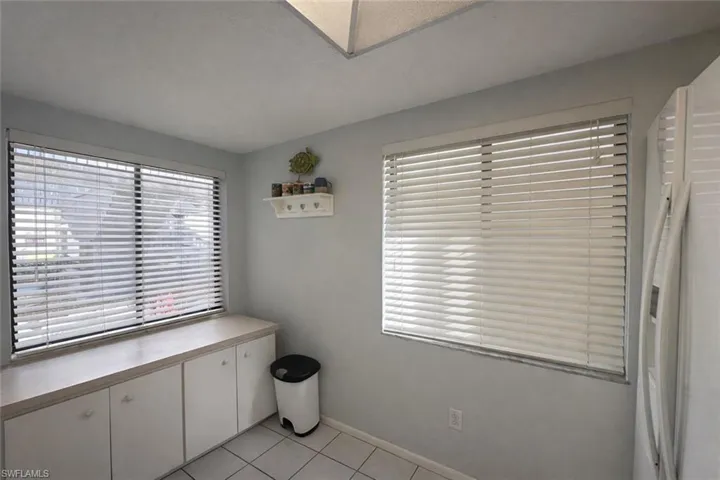 Unfurnished dining area with light tile patterned floors and baseboards