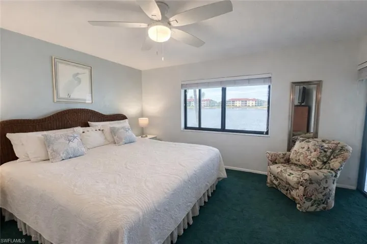 Bedroom with a ceiling fan and dark colored carpet