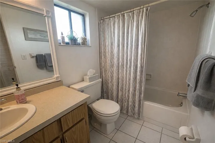 Full bath featuring vanity, shower / bath combo, and light tile patterned flooring