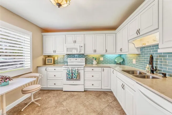 Beautiful updated kitchen with KraftMaid cabinets, granite counters and sea glass subway tiles.