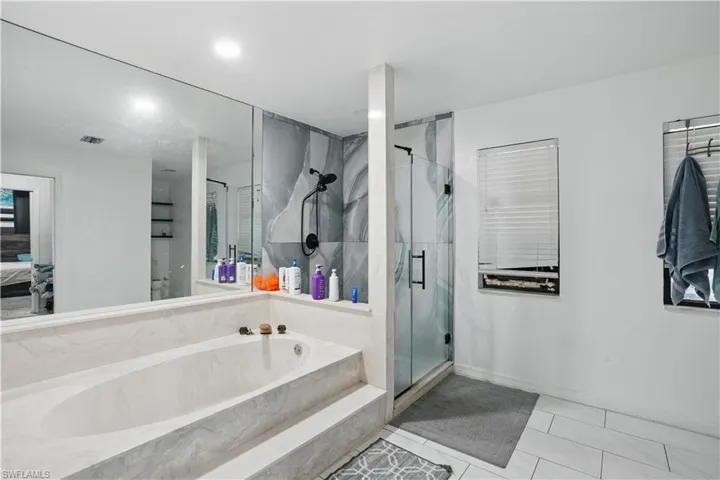 Ensuite bathroom with a marble finish shower, a bath, and tile patterned floors