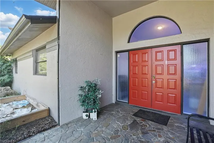 View of exterior entry with stucco siding and a patio area