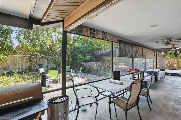 Sunroom / solarium with outdoor dining area and a ceiling fan